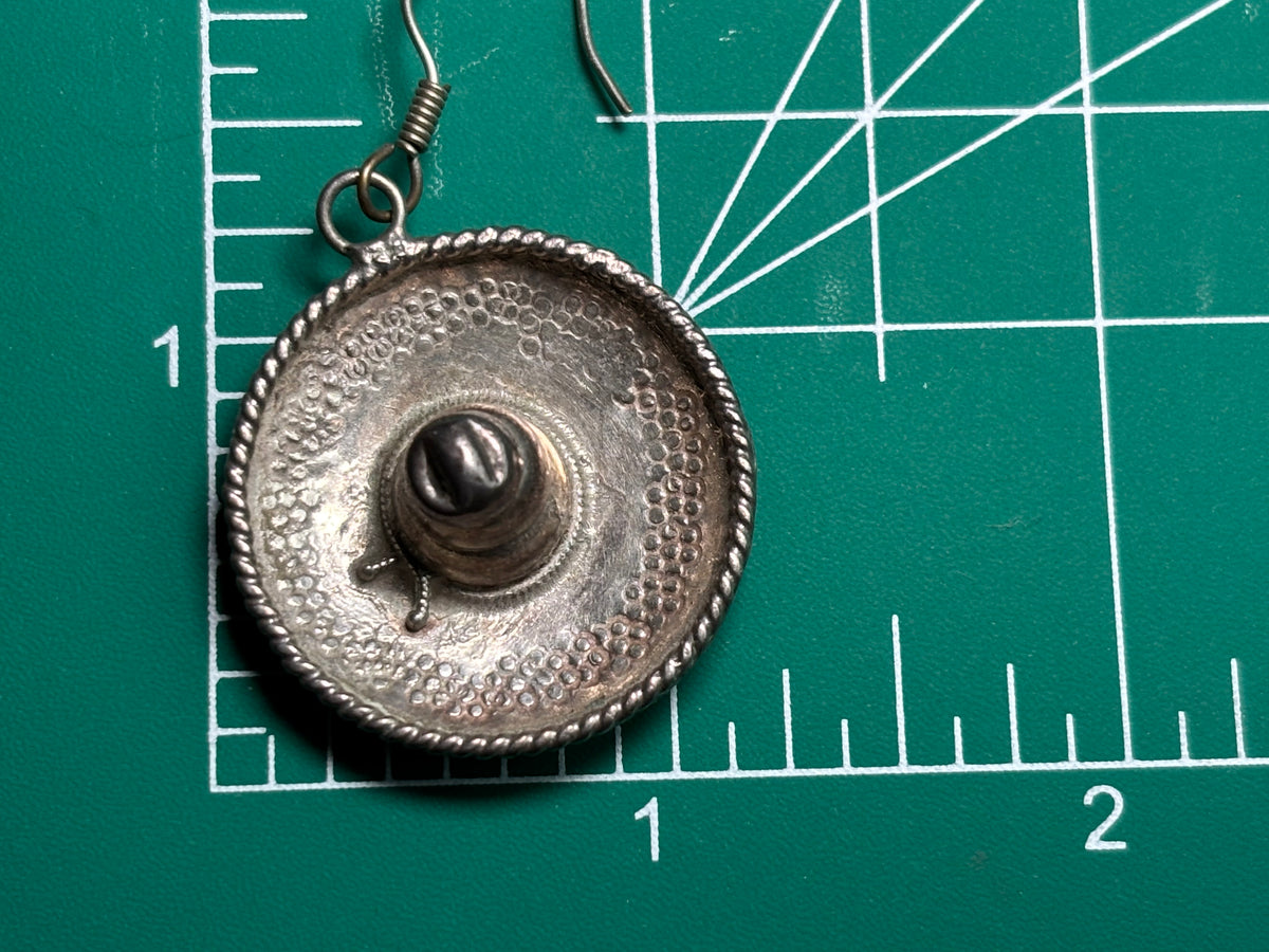 earring on a ruler showing its size - approximately 1 .5 x 1.25 inches