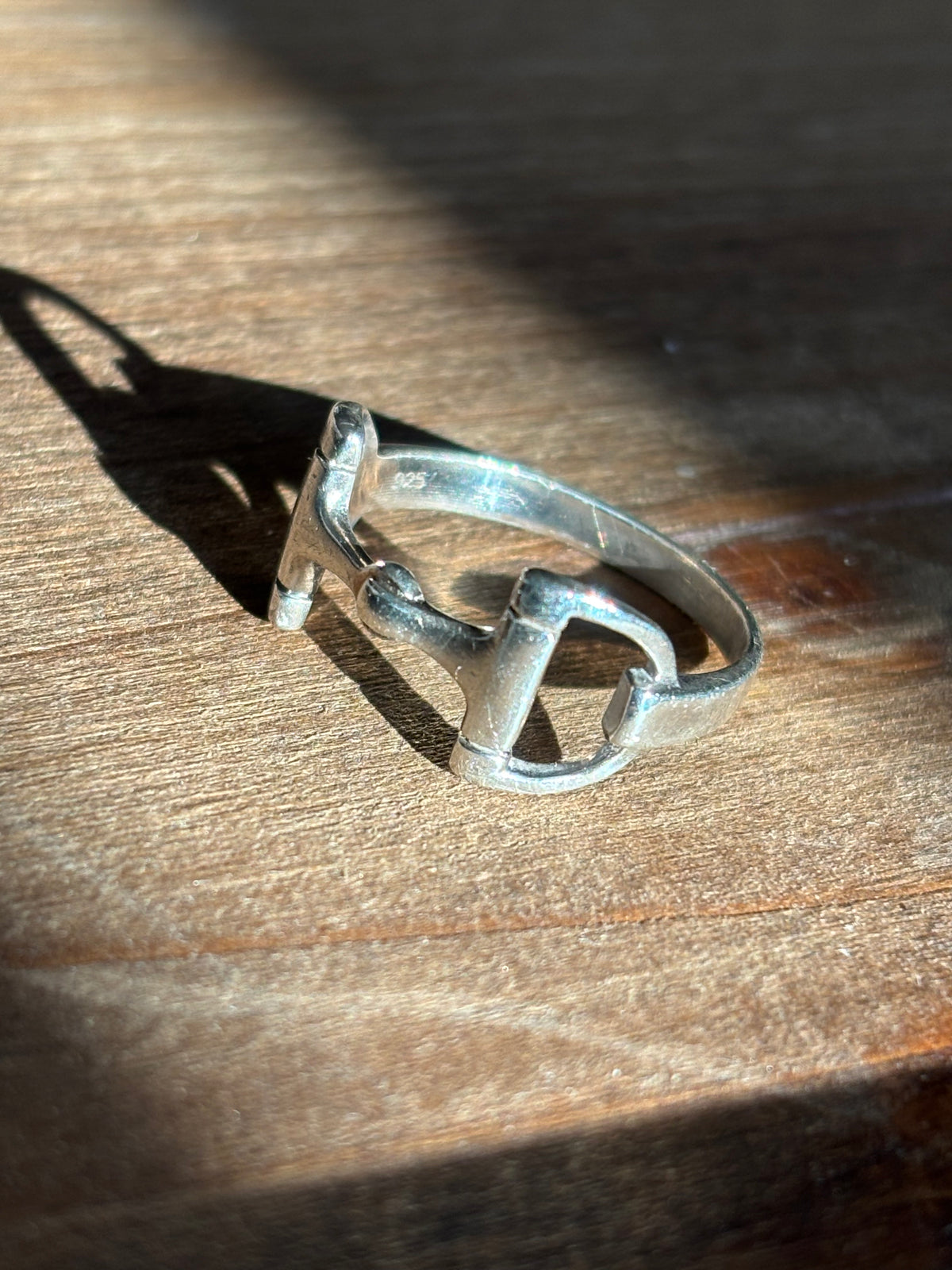 Side view of 925 sterling silver horsebit ring showing the open stirrup-shaped detail and slim polished band.
