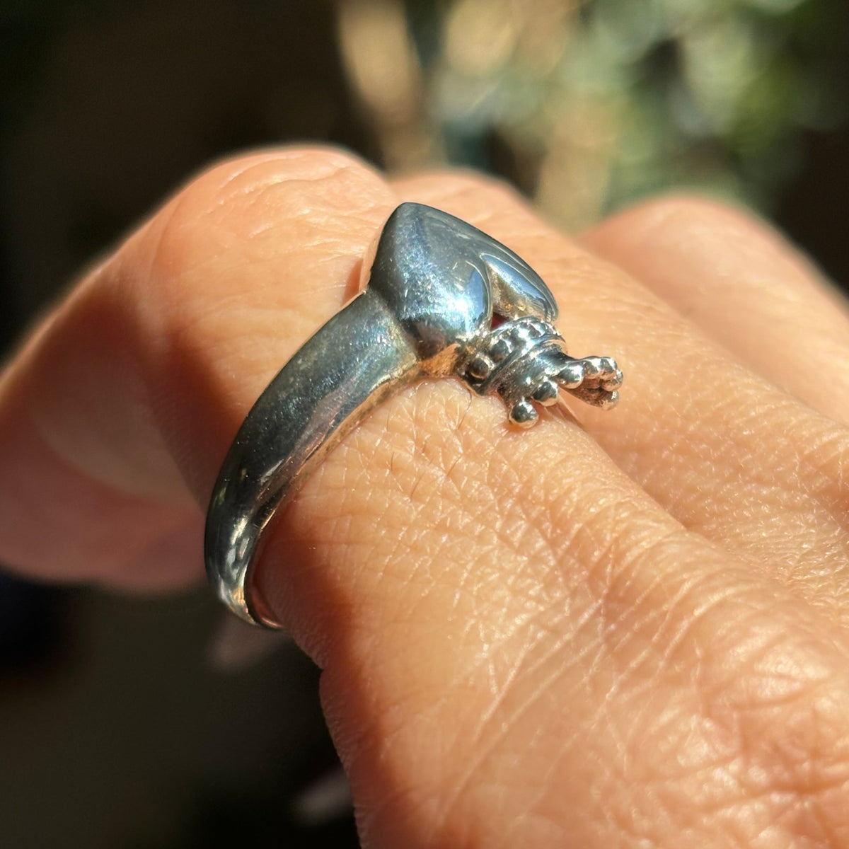 Side view of silver crowned heart ring showing the dimensional heart, raised crown and smooth tapered band.