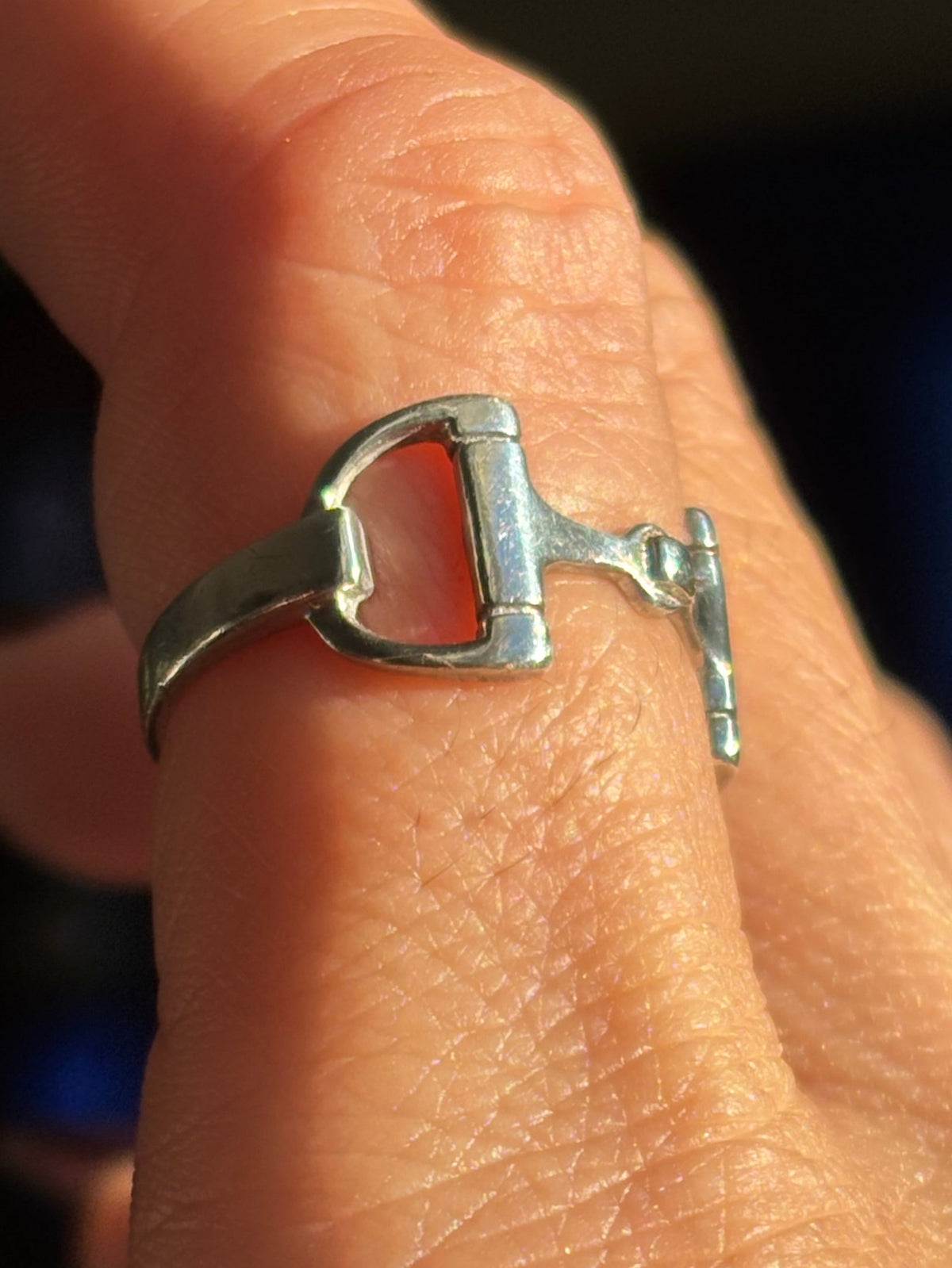 Side view of 925 sterling silver horsebit ring showing the open stirrup-shaped detail and slim polished band.