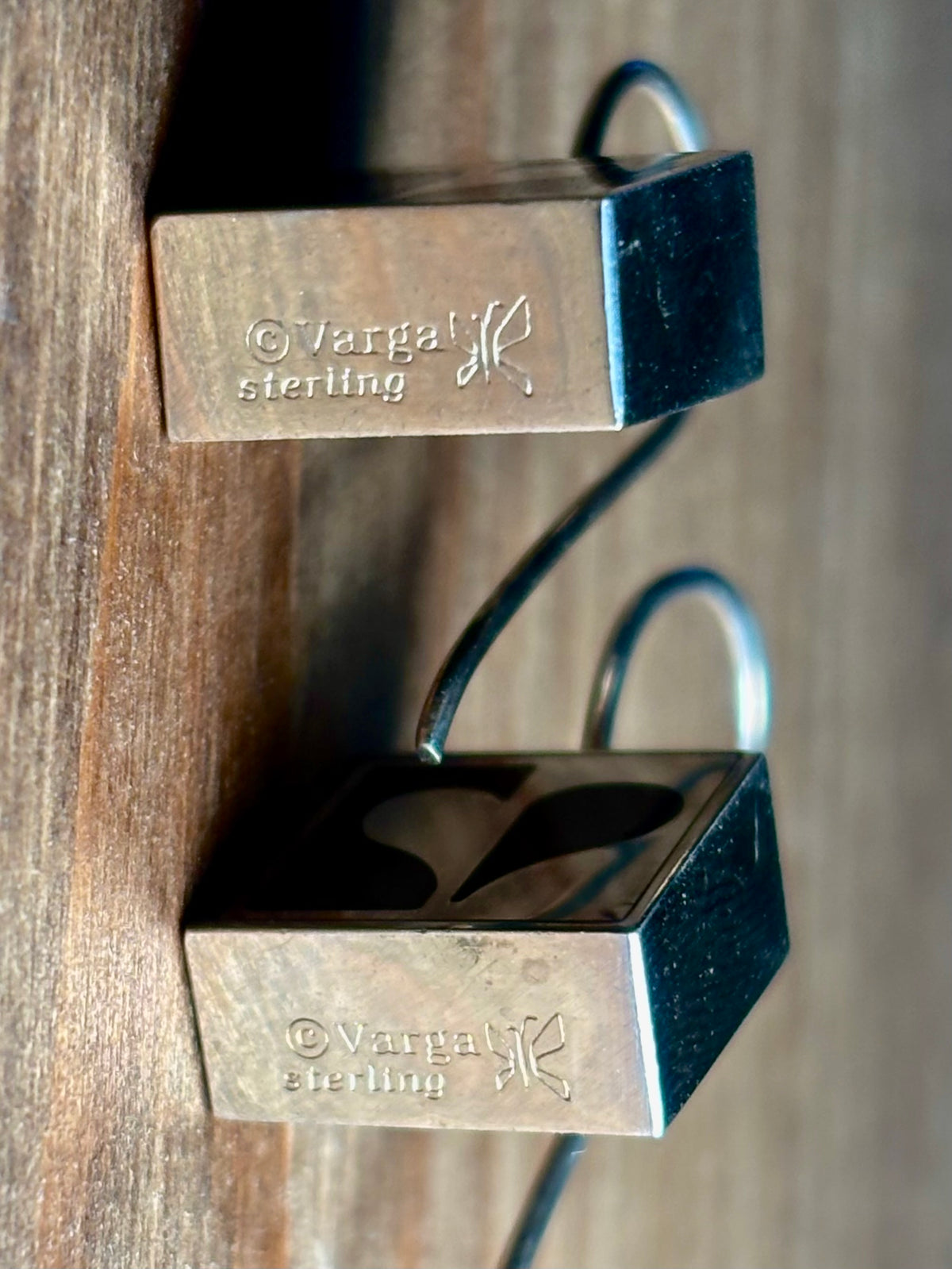 Another view of a close-up of Vargas sterling silver earrings showing the © Vargas signature, sterling stamp, and designer symbol.