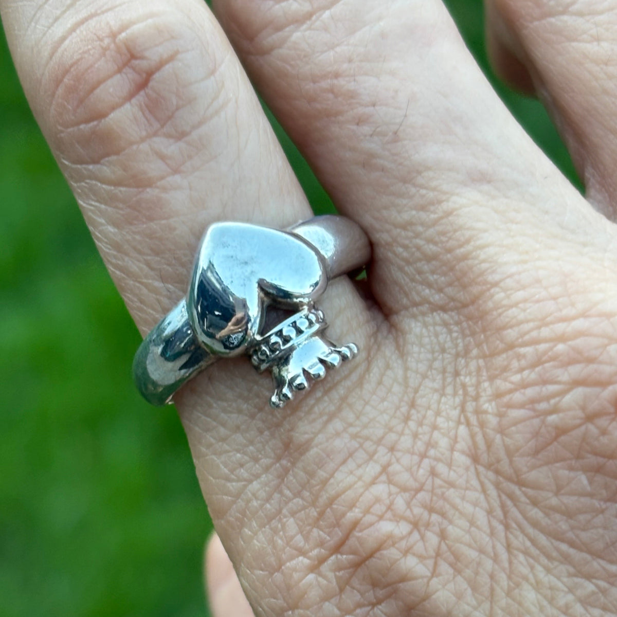 Sterling silver crowned heart ring on a womans ring finger