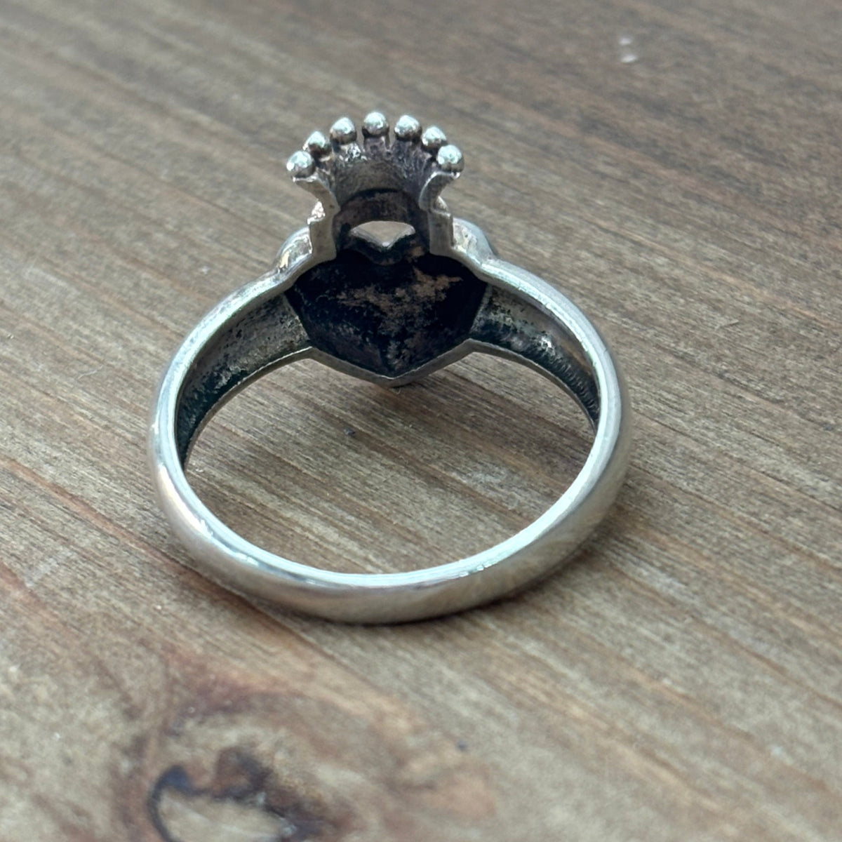 Rear view of sterling silver crowned heart ring showing the underside of the heart setting, crown detail and polished band.