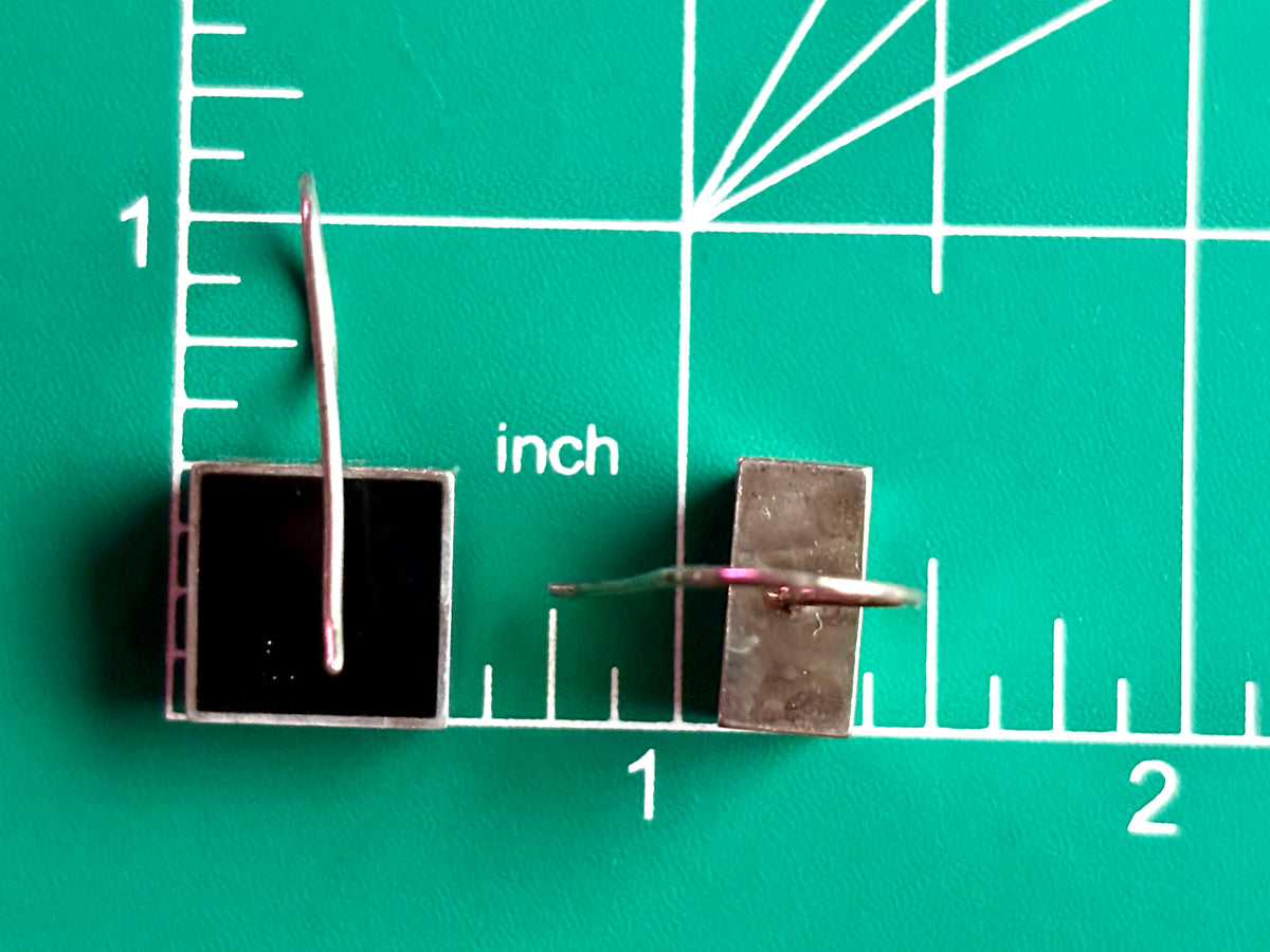 Square Vargas sterling silver earrings beside an inch ruler showing the approximate size of each drop.
