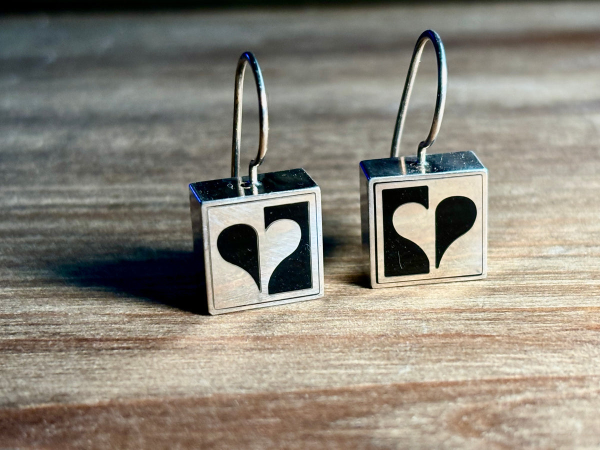 Pair of Victoria Varga sterling silver square French wire earrings featuring a contrasting black and silver half-heart geometric design.