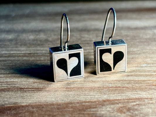 Pair of Victoria Varga sterling silver square French wire earrings featuring a contrasting black and silver half-heart geometric design.